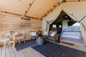 哈士汀Villas & Vines Glamping的帐篷内的卧室,配有一张床和一张桌子