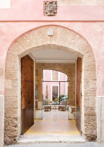 马略卡岛帕尔马帕劳萨丰特酒店的通往粉红色建筑庭院的拱门