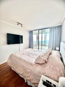 康康Costa de Montemar Full Vista al mar的一间卧室配有一张大床和电视