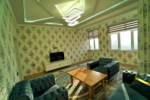 杜尚别Family 3-room apartment的客厅配有蓝色的沙发和木桌
