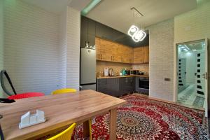 杜尚别Family 3-room apartment的厨房配有木桌和冰箱。