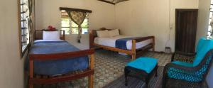 Naviti IslandYawekata Eco Still Bluewater Resort的一间设有两张床和两把椅子的房间