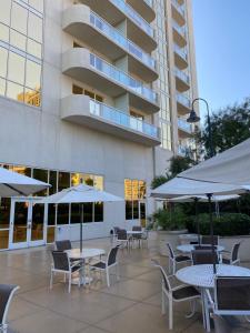 拉斯维加斯MGM Signature Condo Hotel by Owner - No Resort Fee !!的一个带桌椅和遮阳伞的户外庭院。