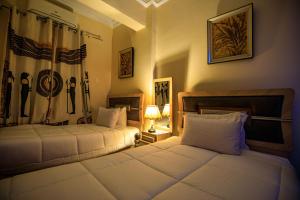 开罗Bella Casa Pyramids Inn的一间卧室配有两张床和一盏灯及窗帘