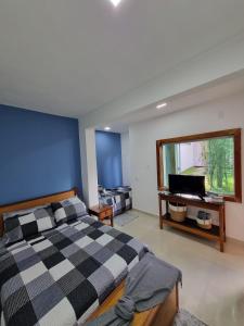Armacao dos BuziosCasa Mar的一间卧室配有一张可调节的床和一台电视机