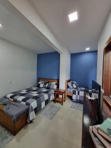Armacao dos BuziosCasa Mar的蓝色墙壁客房的两张床