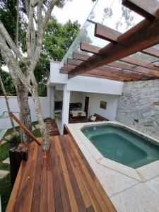 Armacao dos BuziosCasa Mar的房屋旁的木甲板上的游泳池