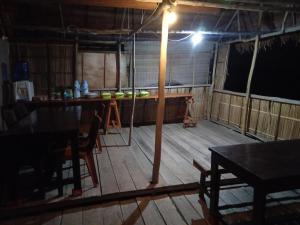 BesirSunset homestay的客房铺有木地板,配有桌子和灯