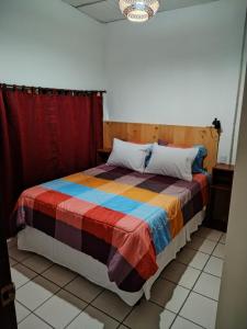危地马拉Granja Triple A的一间卧室配有一张带彩色毯子的床