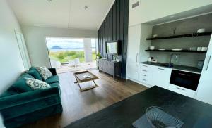 陶朗加Guesthouse @ Te Puna的一间带绿色沙发的客厅和一间厨房