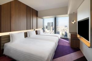 东京HOTEL GROOVE SHINJUKU, A PARKROYAL Hotel的双床间 - 带2张床 - 带平面电视的酒店客房