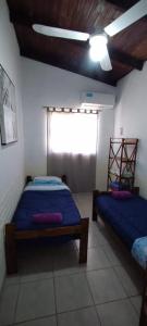 科洛尼亚卡洛斯佩莱格里尼Cabaña Nde Roga的一间卧室设有两张床和窗户。