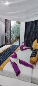 公主港Carpe Diem Villas & Resort的一张带紫色毯子和枕头的床