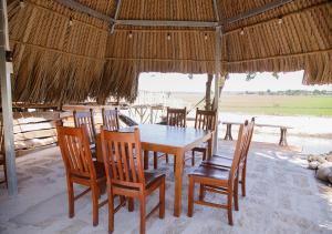 Ba RiaLUA Farmstay的稻草小屋内的餐桌和椅子