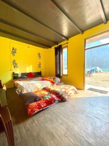 卡索尔Damnbro Cafe & Stay KASOL的黄色客房中一间带两张床的卧室