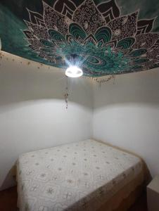 阿祖尔海SHANTI - HOME MAR AZUL的一间卧室配有一张天花板上绘画的床