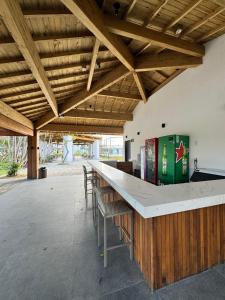 普拉亚多Apartamento studio novo e completo em Praia do Forte! 900m da Vila!的酒吧位于带木制天花板和椅子的建筑内