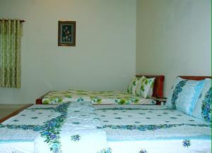 Sa ÐécKhách sạn Hương Sen Sa Dec的配有两张单人床的房间的一张床铺