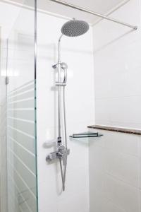 仁川市仁川永宗酒店的浴室铺有白色瓷砖,设有淋浴。