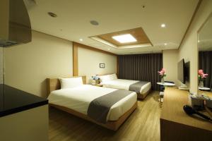 仁川市仁川永宗酒店的酒店客房设有两张床和电视。