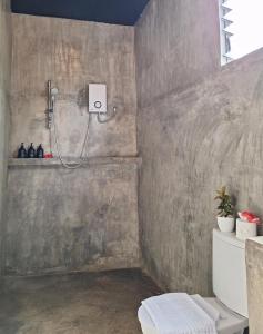 San IsidroBamboo Surf Beach的浴室设有混凝土墙,配有淋浴