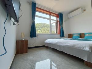 密云古北口长城聚仙居民宿的一间卧室设有一张床和一个窗口