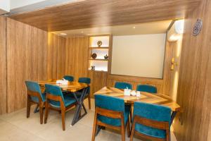 加德满都Ananta Home的一间设有两张桌子和蓝椅的用餐室