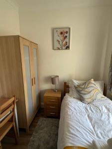 伦敦Comfortable Single Room Wembley Park/Stadium的一间卧室配有一张床和一张带台灯的桌子