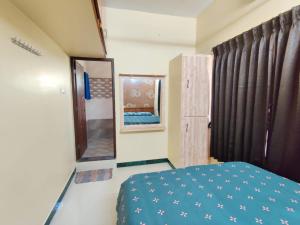 哥印拜陀luxury home in Vadavalli的一间卧室配有蓝色的床和镜子