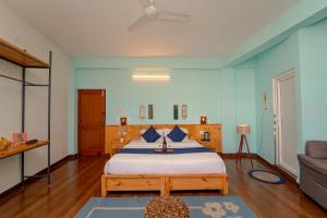 比尔瓦Chokling ArtHouse - The Treasure of Himalayas的一间卧室配有一张带蓝色墙壁的大床