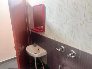 因帕尔OYO Decent Inn的浴室设有水槽和墙上的镜子