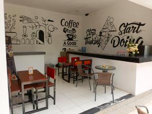 岩望NK Villa Syariah And Cafe Prigen的餐厅设有桌椅,墙上涂鸦