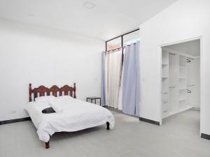 圣何塞Apartamento Bellavista en San Jose的白色卧室配有床和镜子