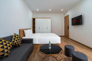 河内Casa Feliz Serviced Apartment的酒店客房,配有床和沙发