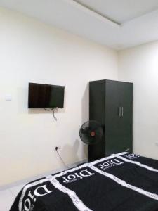 AbeokutaF&B Service Apartment的一间卧室配有一张床和一台平面电视