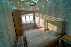 杜尚别Family 3-room apartment的一间带床的卧室,位于带窗户的房间内