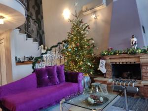 沃洛斯Dana's Luxury Maisonette的客厅配有紫色沙发和圣诞树