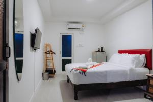 华欣Amit Resort 51 Hua Hin的一间白色卧室,配有床和电视