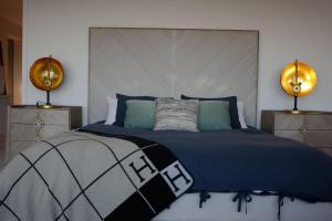 洛杉矶Skyline Serenity Luxe Suite-Private Room的一间卧室配有一张带蓝色被子的床和两盏灯。