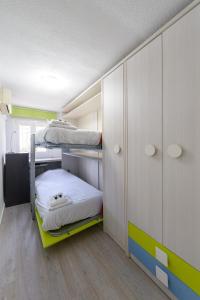 马德里Casa familiar Sabadell de 3 dormitorios junto metro Fuencarral的客房设有两张双层床和橱柜。