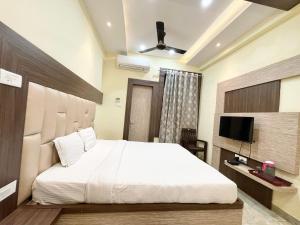 瓦拉纳西Hotel Nandini Palace ! Varanasi ! ! fully-Air-Conditioned-hotel family-friendly-hotel, near-Kashi-Vishwanath-Temple and Ganga ghat的一间卧室配有一张大床和电视