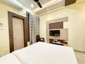 瓦拉纳西Hotel Nandini Palace ! Varanasi ! ! fully-Air-Conditioned-hotel family-friendly-hotel, near-Kashi-Vishwanath-Temple and Ganga ghat的一间卧室配有一张床和一台平面电视