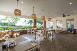 普拉亚Swiss-Belcourt Lombok的用餐室设有桌椅和窗户。
