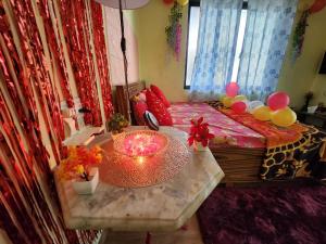 阿利鲍格Bhumi Holiday Home的配有一张带蜡烛的桌子的床的房间
