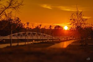 武科瓦尔STUDIO APARTMAN 404的一座河上的桥梁,背面是日落