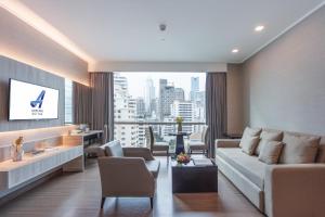 曼谷 和阿德尔菲套房的带沙发和大窗户的客厅