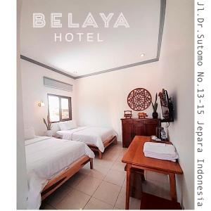 哲帕拉Belaya Hotel的酒店客房设有两张床和一张桌子。