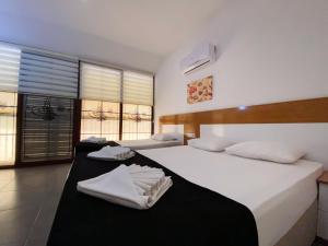 厄吕代尼兹泽赫拉全包酒店的一间卧室配有两张床、白色的床单和毛巾。
