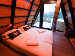 Ban Huai Sok NoiRoomQuest Kid Tung Khao的一间带一张大床的卧室,位于带窗户的房间内
