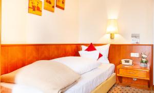 诺德奈Hotel Friese的一间卧室配有一张床、床头柜和台灯